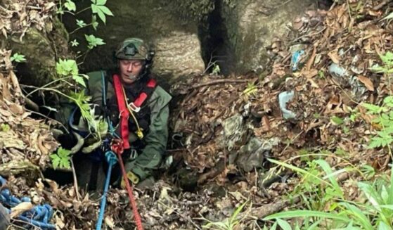 Hawkins County Rescue Squad member carrying dog that fell down a sinkhole.