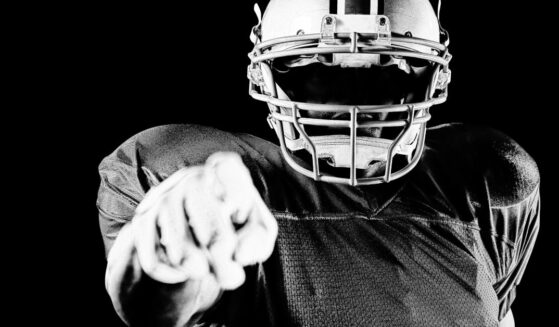 Portrait close up of American male football player wearing team uniform.