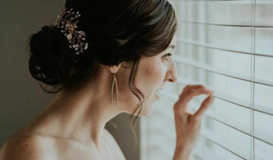 Bride on wedding day looking out the window.