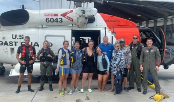 Coast Guard poses for a picture with the group they rescued.