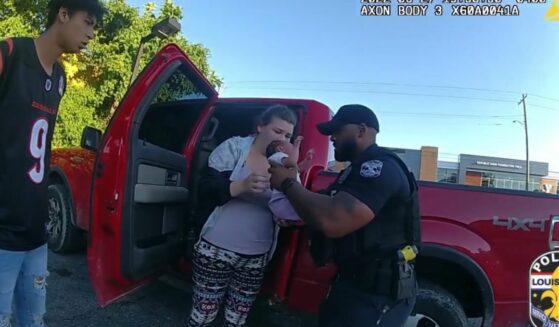 Officer performs CPR on infant that is struggling to breathe.