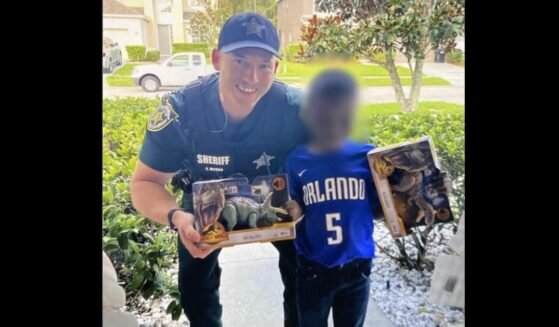 Deputy with little boy and his new dinosaur toys.
