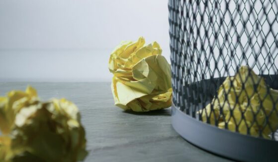 Photo of yellow paper near trash can.