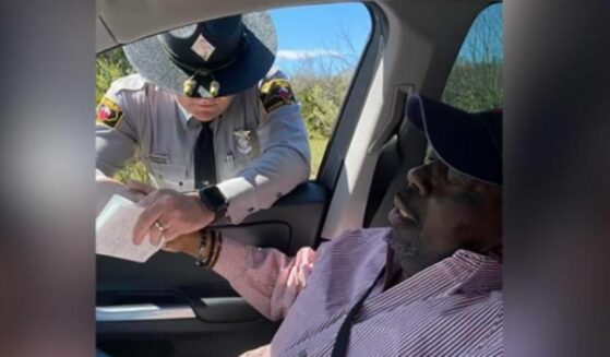 State trooper prays with traffic violator's father.