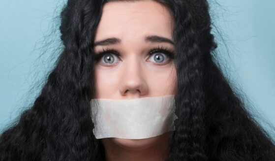 Girl with mouth taped.