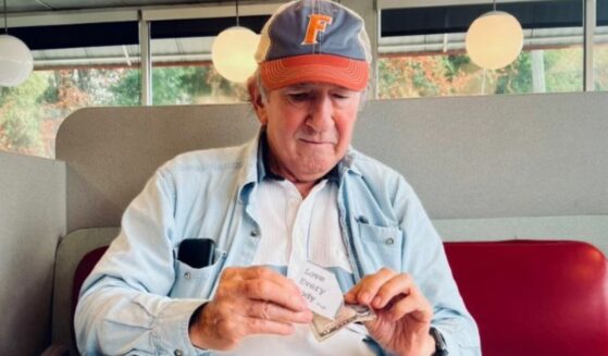 Man prepares notes and cash to pass out to strangers at Waffle House.