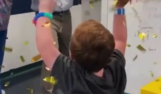 Henry celebrates being cancer free as staff sing him a celebratory song and he rings the bell.