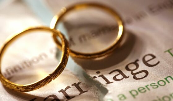 Shot of word marriage and two wedding bands on top.