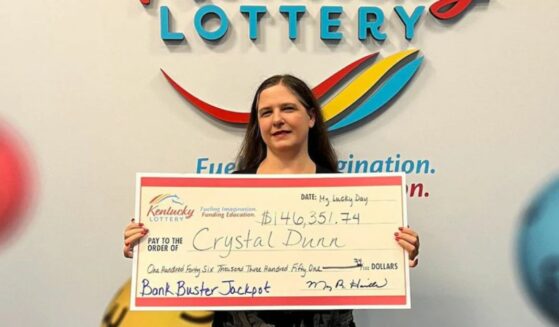 Crystal Dunn poses with the check she won from the Kentucky Lottery.