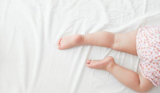 Legs of toddler sleeping in bed.