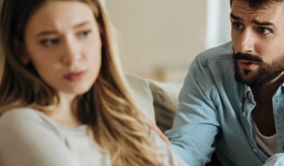 Young man asks girlfriend for forgiveness at home.