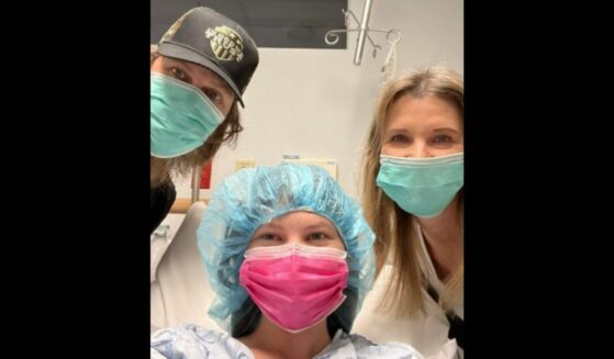 Mia Robertson poses for a picture with her parents before her 14th surgery.
