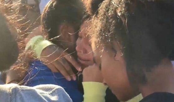 Family and friends of victim Asherey Ryan embrace and weep over their loss.