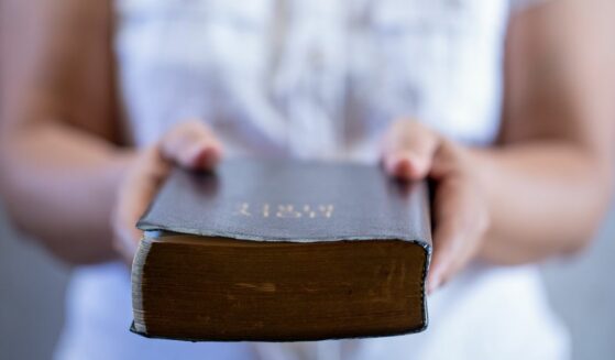 Handing a Bible to a person who is interested in becoming a Christian.