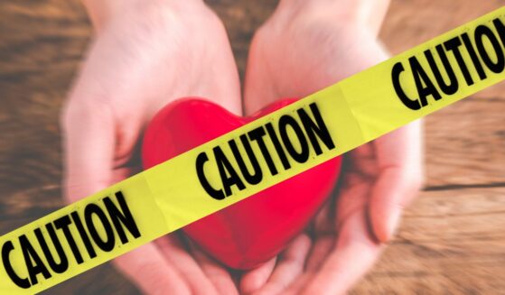 Heart held in hands; Caution tape.