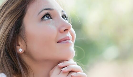 A young woman is praying to God.