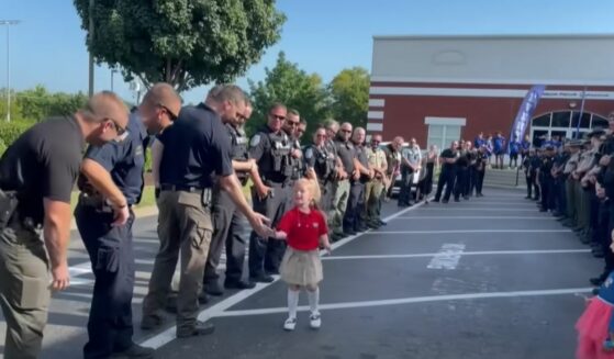 5-year-old Anna Stolinsky high-fives her dad's fellow police officers on her first day of kindergarten.