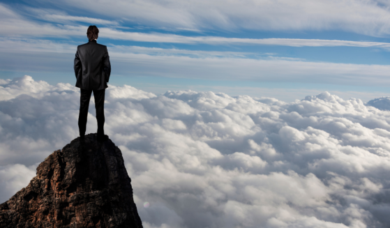 Businessman looking over the clouds from the How Does God Define Success article on Liftable.com