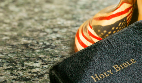 Separation of Church and State Article | Bible and reflection of the American flag symbolic of challenges of the concept of separation of church and state.
