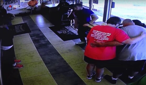 Richard and Doretta Irwin pray for Sarah Schlereth after saving her life at Mann Meats restaurant.