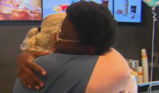 Assistant manager Andrea De La Rosa, nicknamed "Mama McDonald's", gives a hug to 18-year-old Emanuel Graham