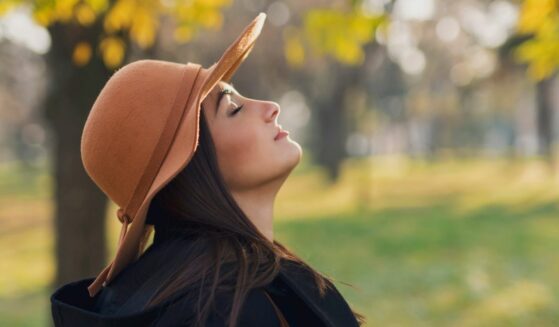 Young woman taking in a deep breath.