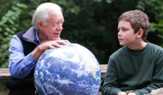 Jimmy Carter sitting with hand on globe talking with grandson Hugo Wentzel.