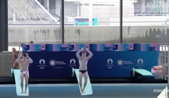 Diver, right, slips during Olympic pool inauguration ceremony with two other divers, left.